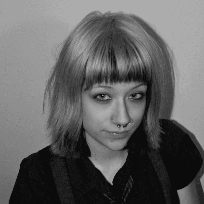 Portrait of Elliot, a professional stylist at Jungle Red Salon, showcasing their expertise and style.